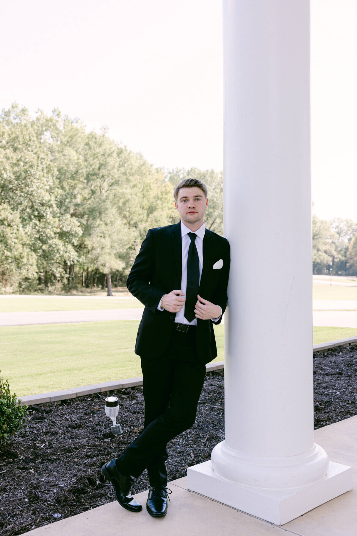 A wedding photo of the groom smiling for the camera