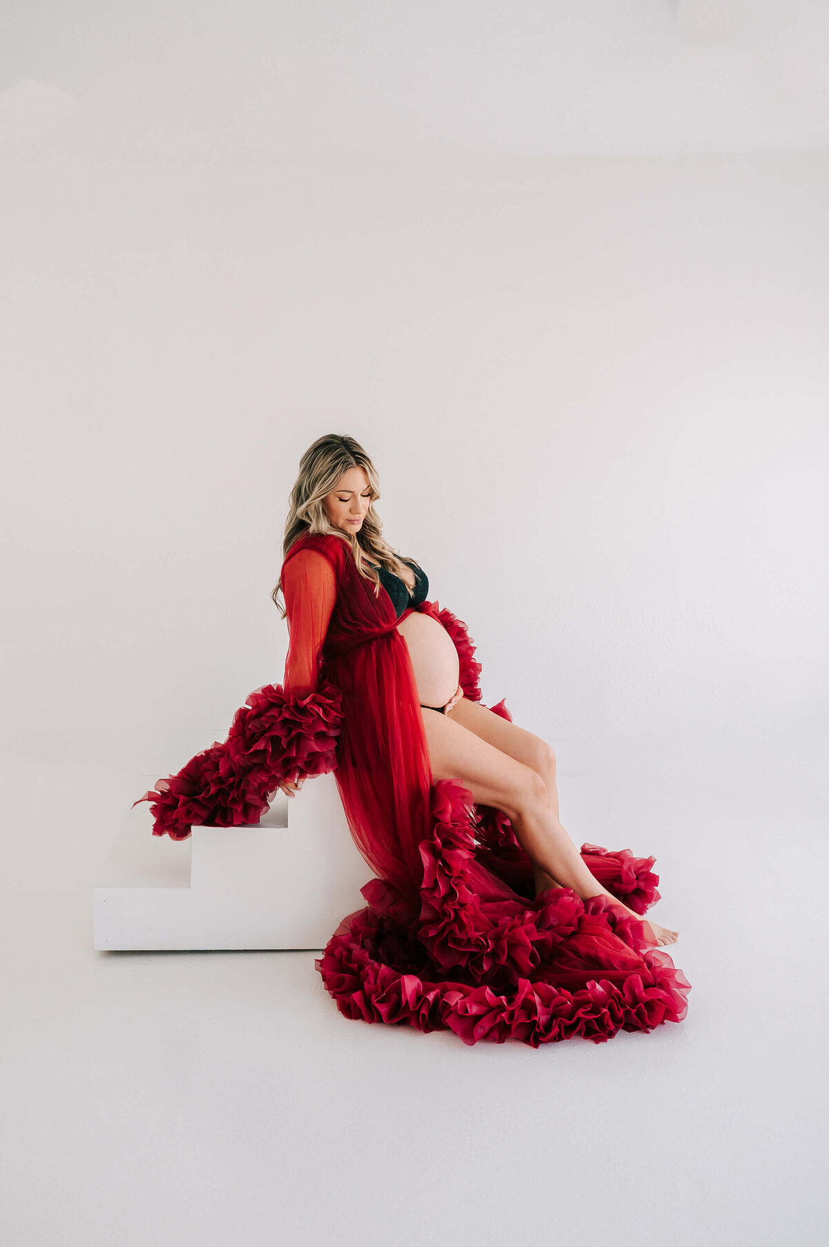 Joplin MO maternity photographer Jessica Kennedy of The XO Photography captures pregnant mom in red robe sitting on step