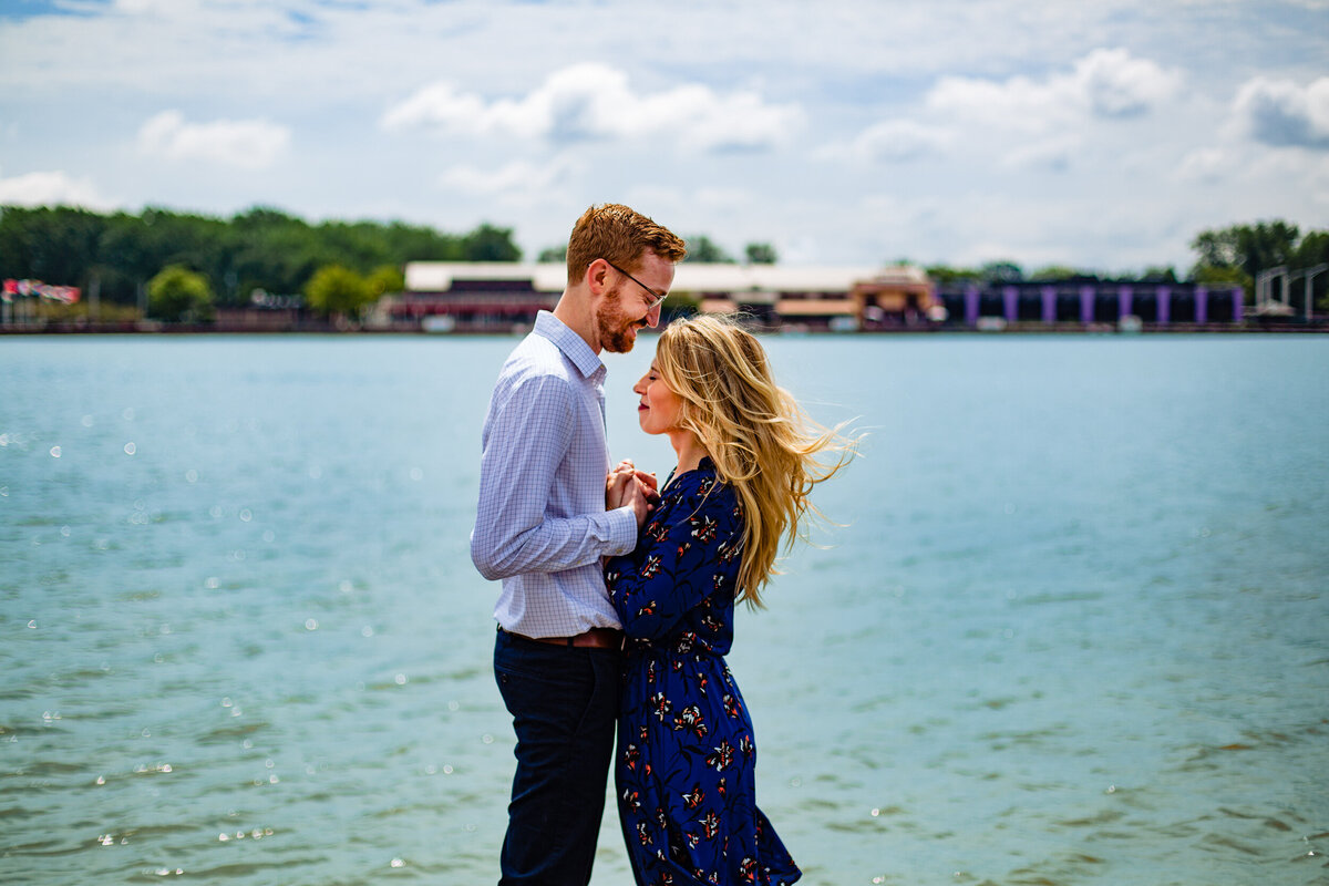 Summer Engagement photo in downtown TOledo Ohio. On the river as the couple embrace each other as the wind blows.  Photo By Adore Wedding Photography. Toledo Wedding Photographers