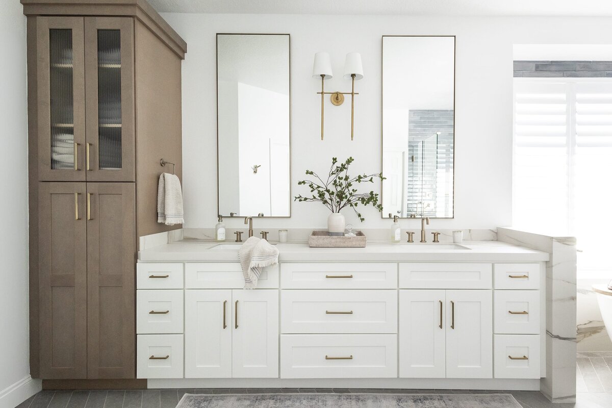 dewine design interiors contemporary coastal primary bathroom with white cabinets and bronze hardware