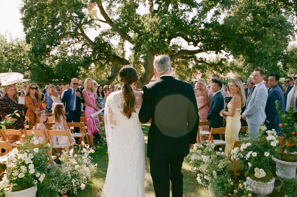 Father walks bride down the aisle during outdoor wedding ceremony