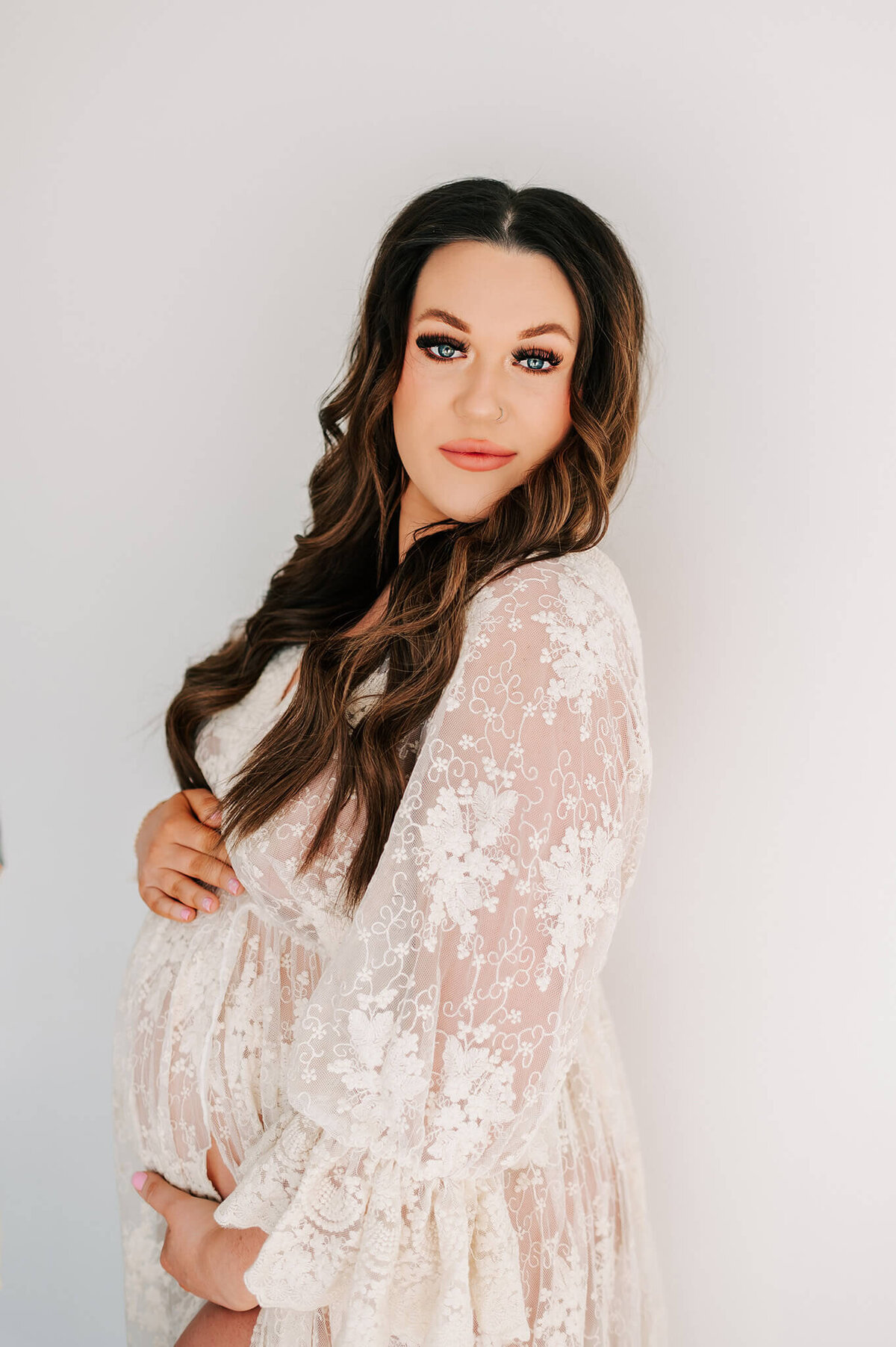 maternity photo of mom in lace dress holding baby bump during Springfield MO photography session