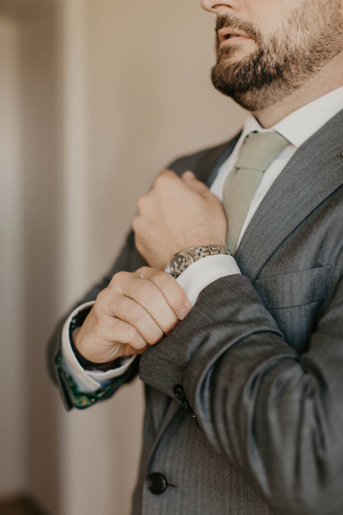 Groom putting on cuff links. 