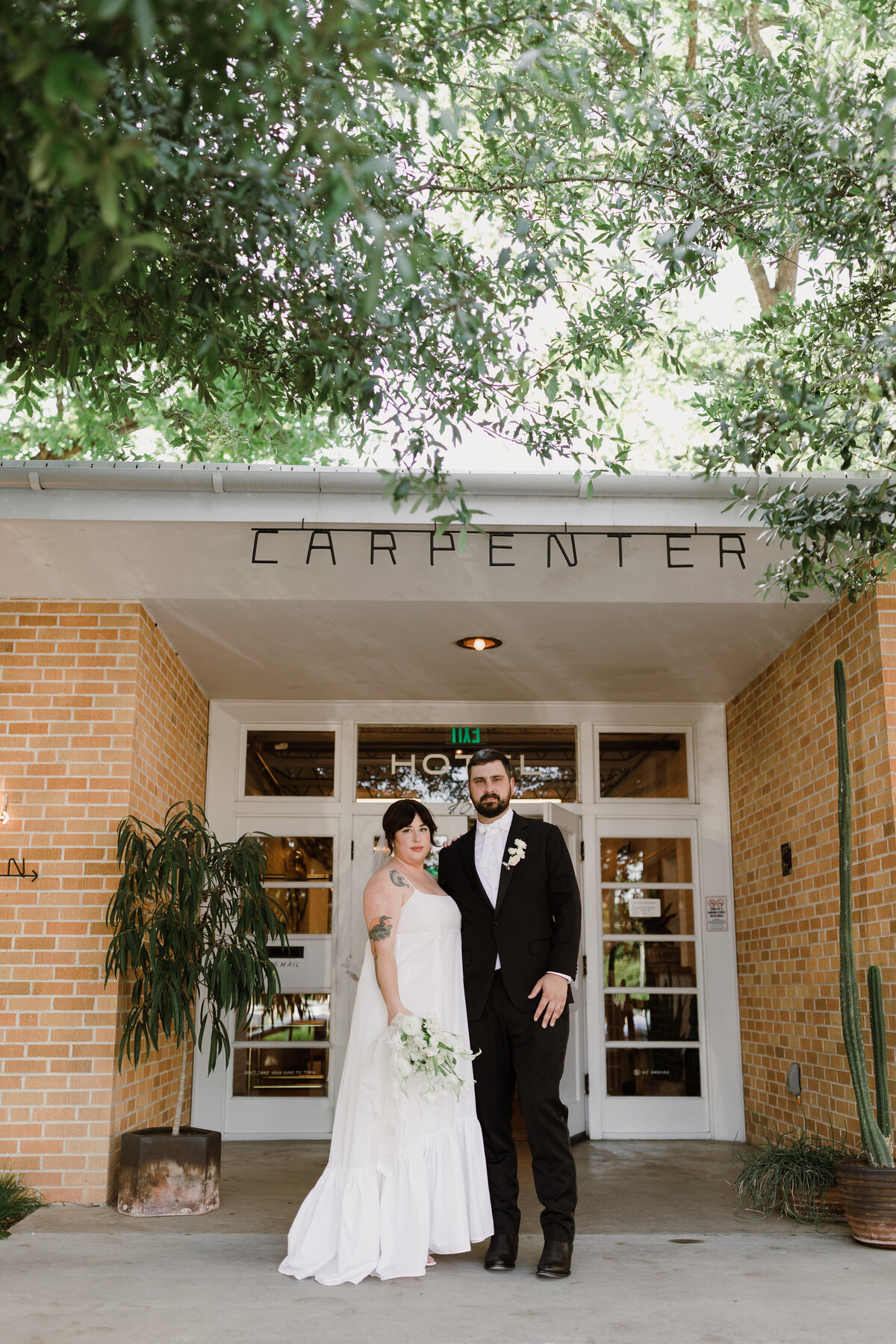 Bride and groom standing outside the Bride and groom portraits at  Carpenter Hotel, Austin
