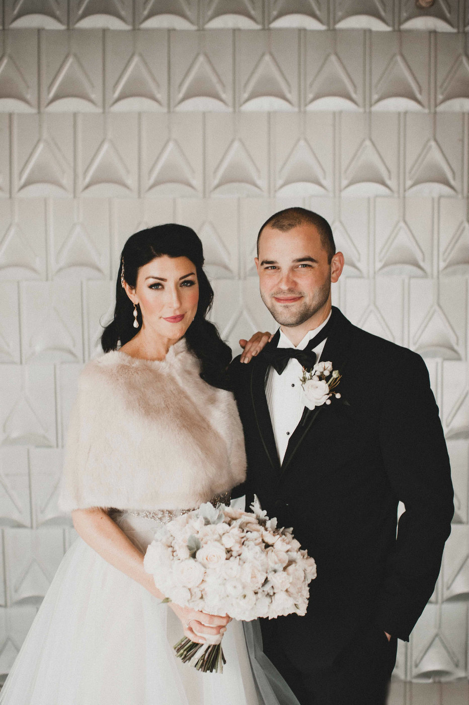 Stunning couple at their winter wedding with floral by Flora Nova Design Seattle, bride in faux fur cape with white bouquet