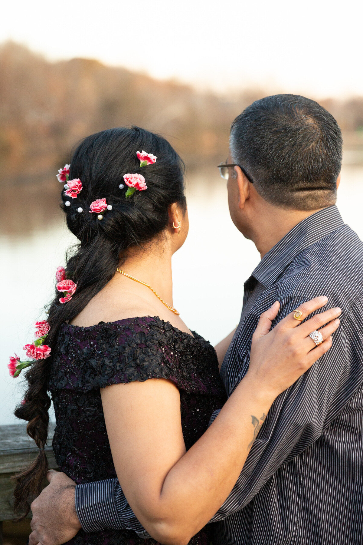 Couple holding each other and looking at towards the water at Occoquan Historic District Wedding Anniversary
