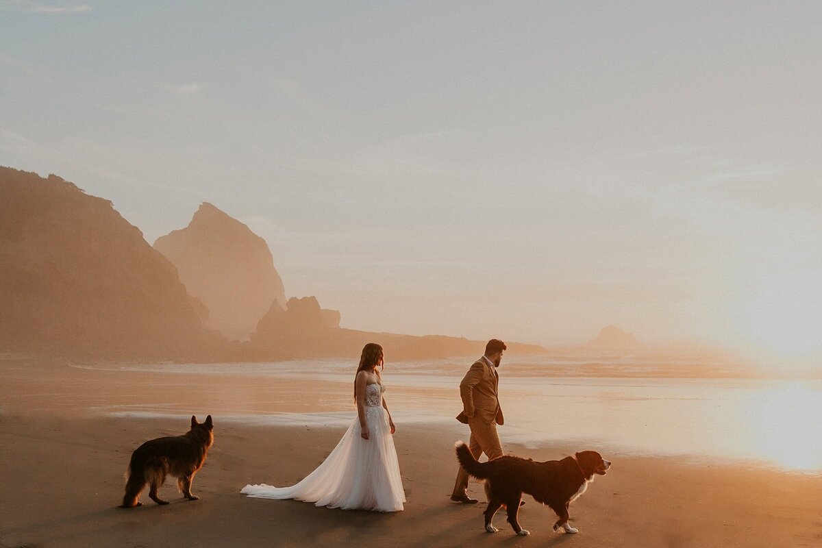 A couple in wedding attire running on an Oregon Coast beach during their elopement
