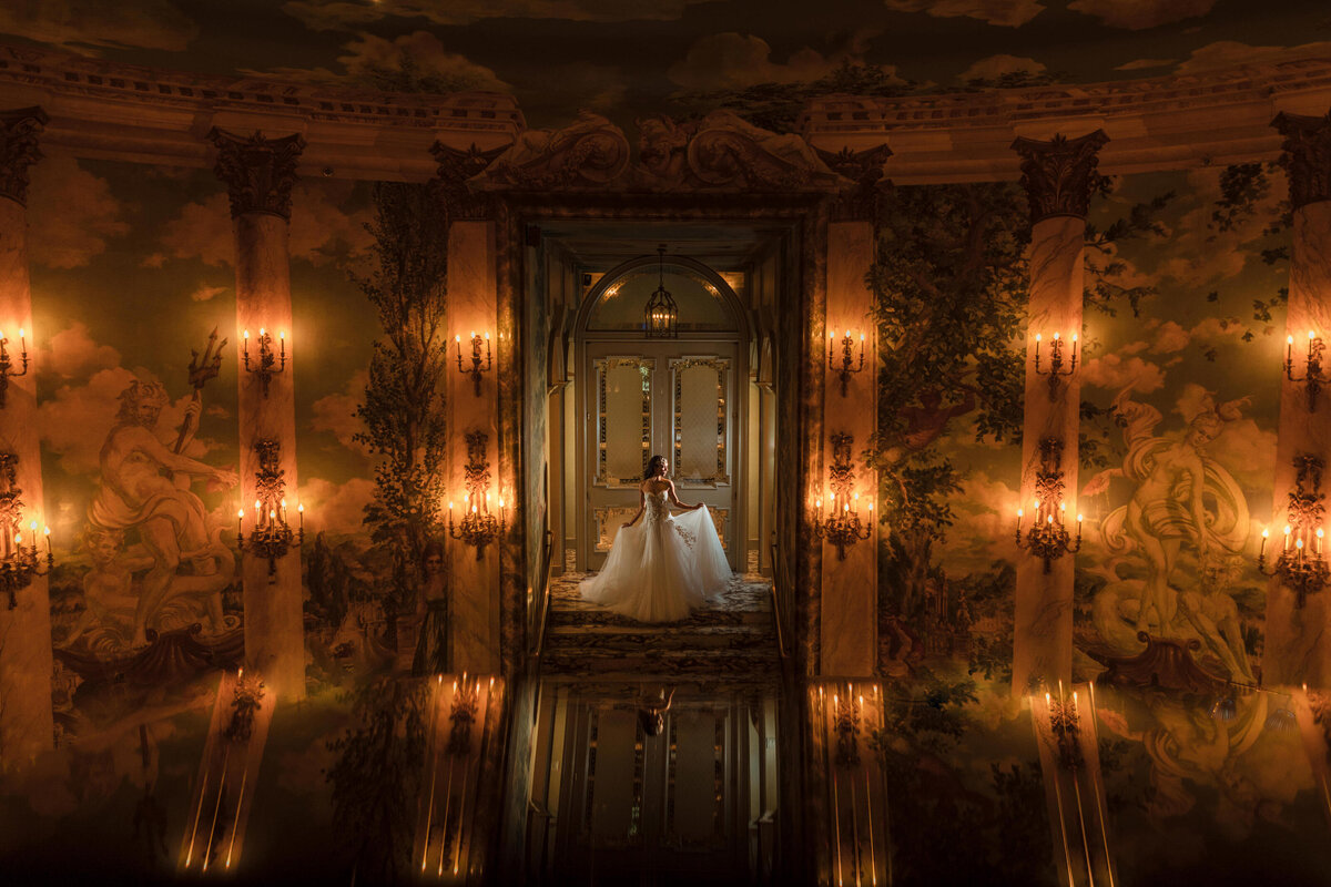 A bride standing in the doorway of an intricately painted room.