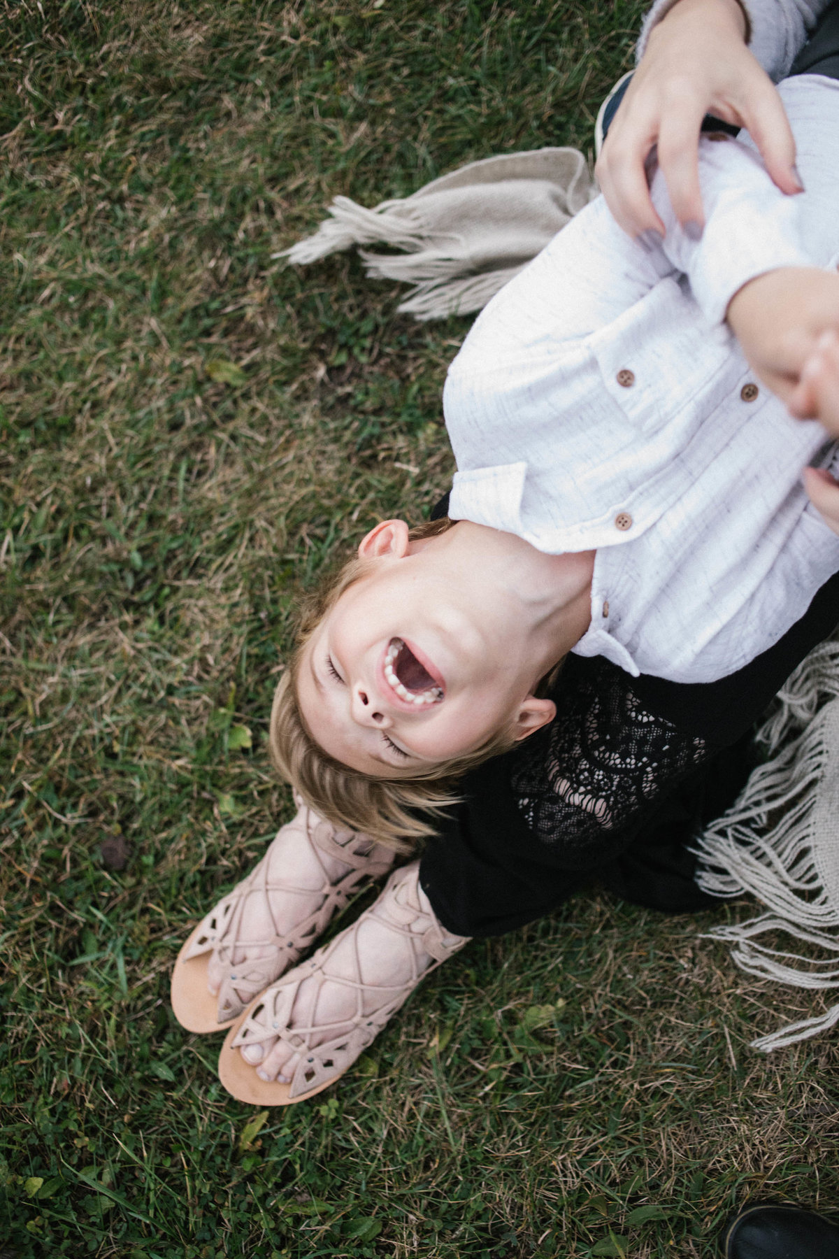 Son laughing as his mother tickles him during sunset session with Elle Baker Photography