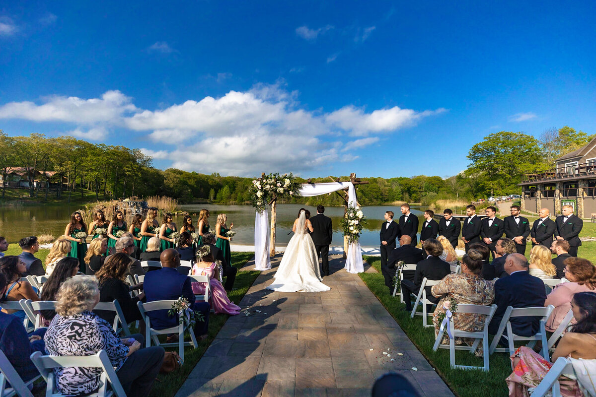 lakeside-wedding-ceremony-with-a-beautifully-decorated-arch-elegant-guests-and-romantic-ambiance