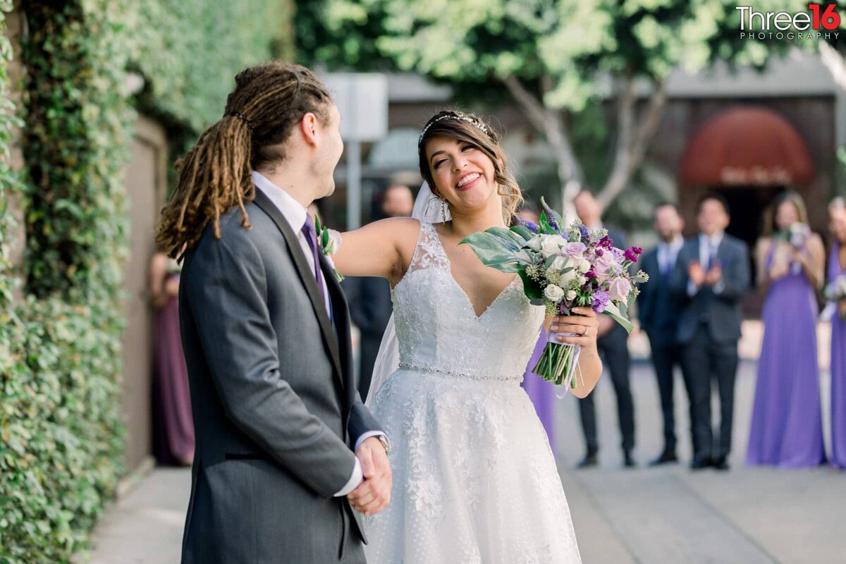 Bride and Groom smile at each other during photo shoot