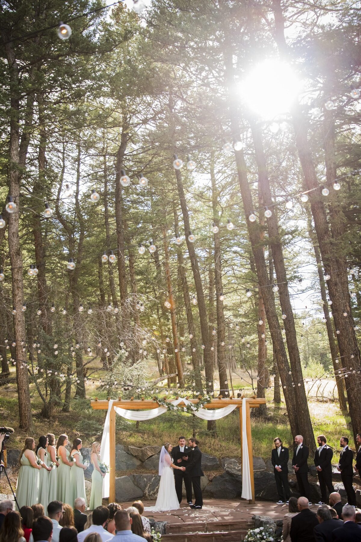 A wide angle shot of a wedding ceremony at golden hour at The Pines at Genesee.
