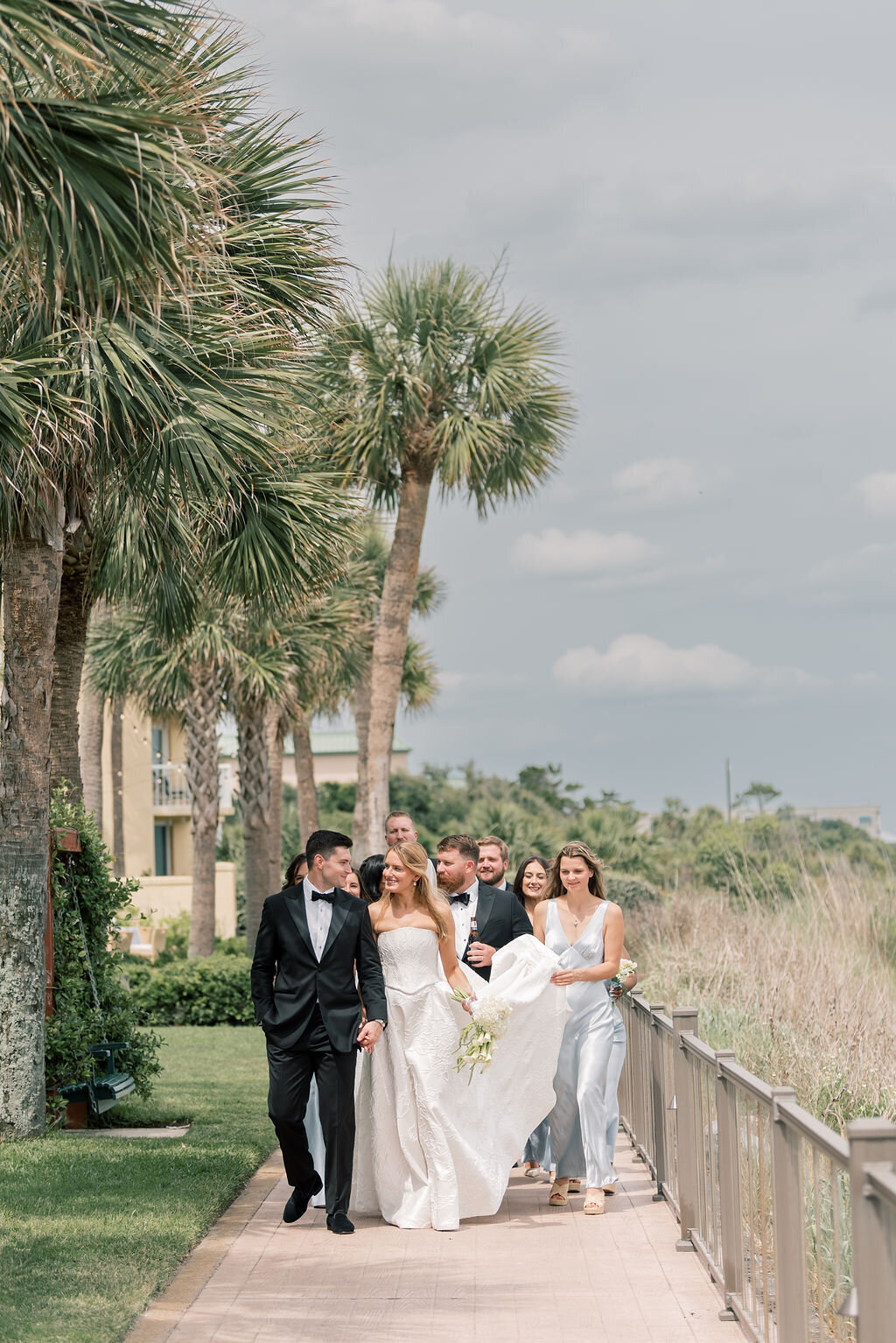 bride and groom with their wedding party walking down the sidewalk taken by St.Simons Island Wedding Photographer, Rhonda Rowell