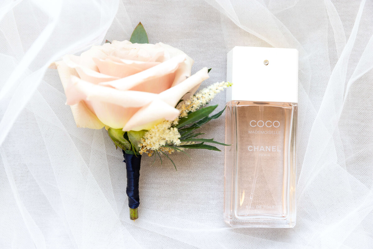 Perfume and a single blush rose