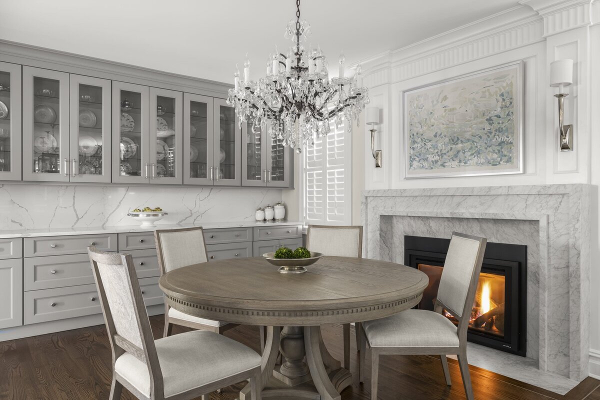 candra lynn interiors ocean port project round dining table with marble mantle and fireplace