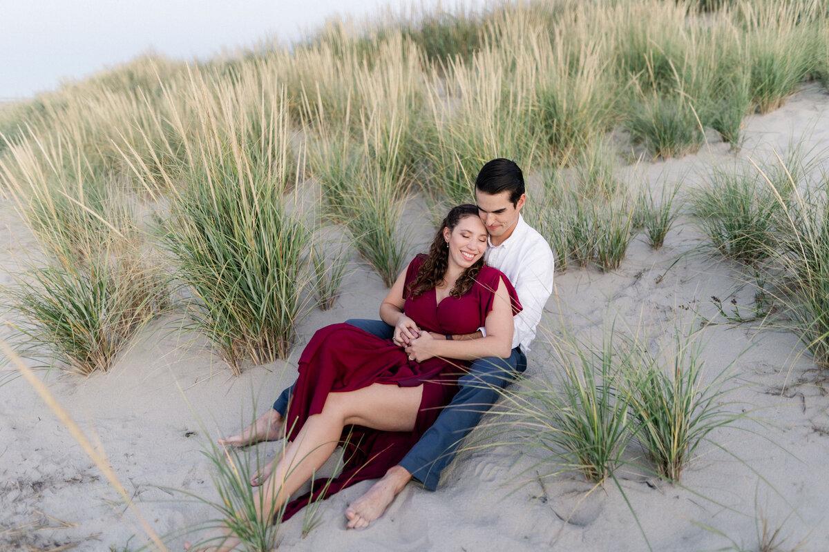 Couple sitting on the sand by the bridge beach in Ocean City NJ