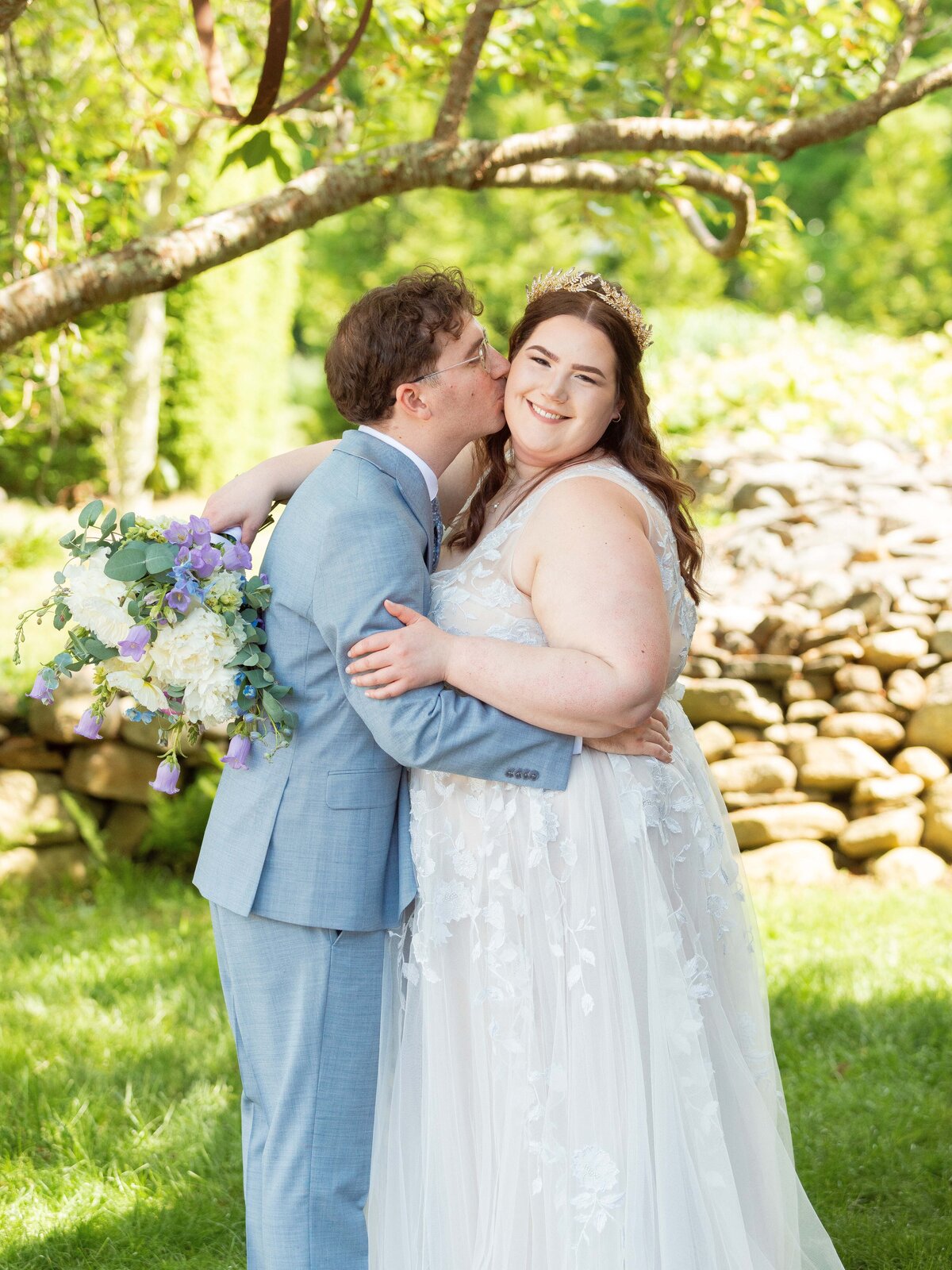 A groom kisses his new wife on the cheek during their wedding at Salem Herbfarm in Salem, CT.