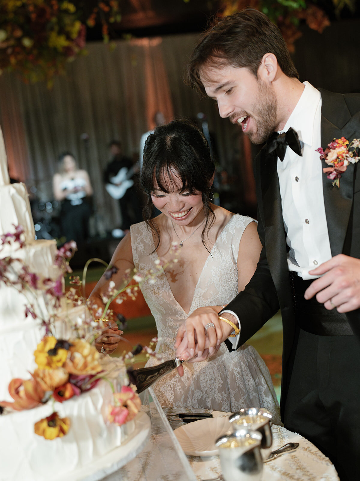 Whimsical and artistic cake flowers for fall wedding reception at private home. Clear top tent build out for fall wedding reception in Tennessee hills. Floral centerpieces featuring orchids, ranunculus, sweet peas, and bittersweet. Styled wedding tables with fruits, curated candles, and floral arrangements. Tasteful fall color palette of copper, ruby, gold, burgundy, rust, and lavender. Design by Rosemary & Finch Floral Design in Nashville, TN.