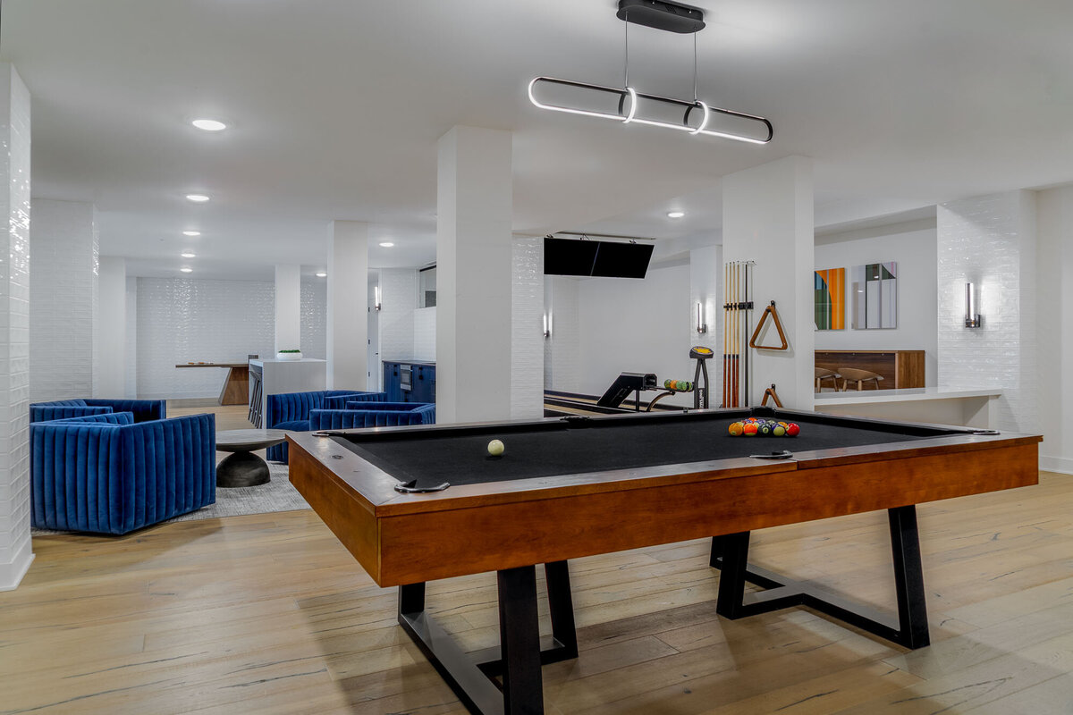Game room design with black and wood pool table and blue sofa