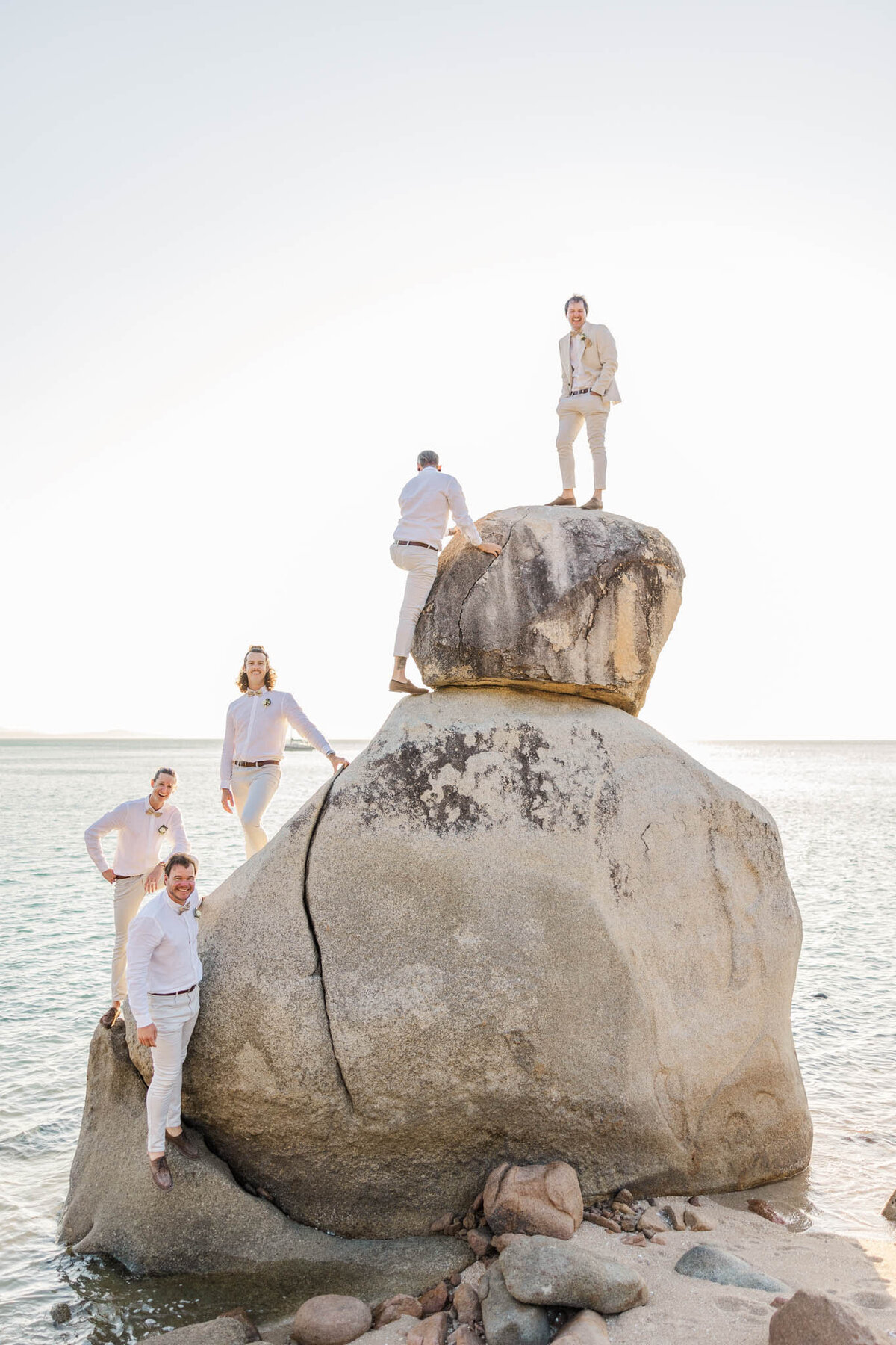Daring groomsmen climb, froggy rock on the grooms Whitsunday wedding day