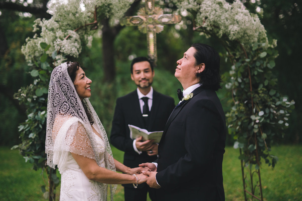 Bride and groom at the alter and groom is looking up as if thanking God for his beautiful bride at the San Antonio wedding venue The Veranda