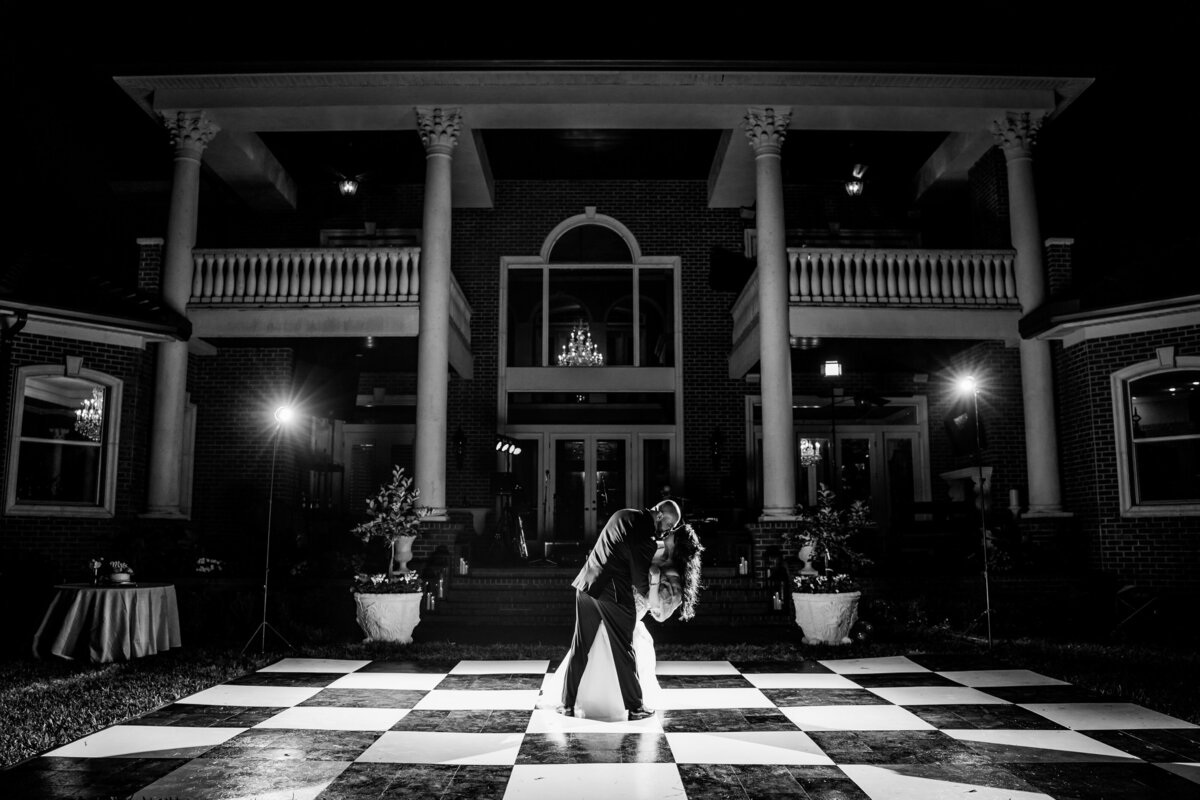 bride and groom share kiss while dipping on dance floor during first dance at a private residence in Jupiter Florida
