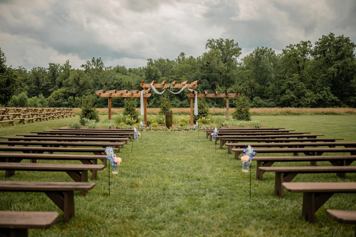 Ceremony aisle with benches leading to the decorated pergola