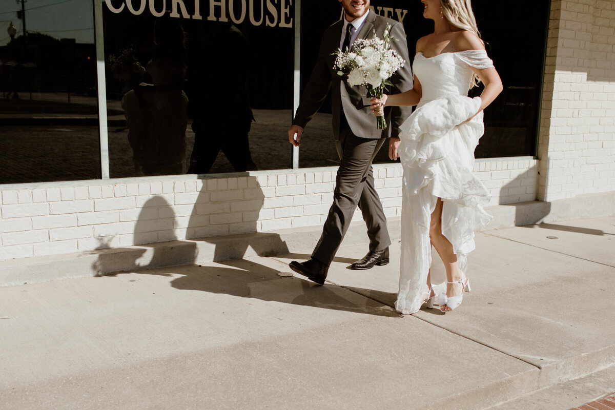 A couple on their way to get married walking through downtown Gainesville, Texas. Captured by Fort Worth wedding photographer, Megan Christine Studio