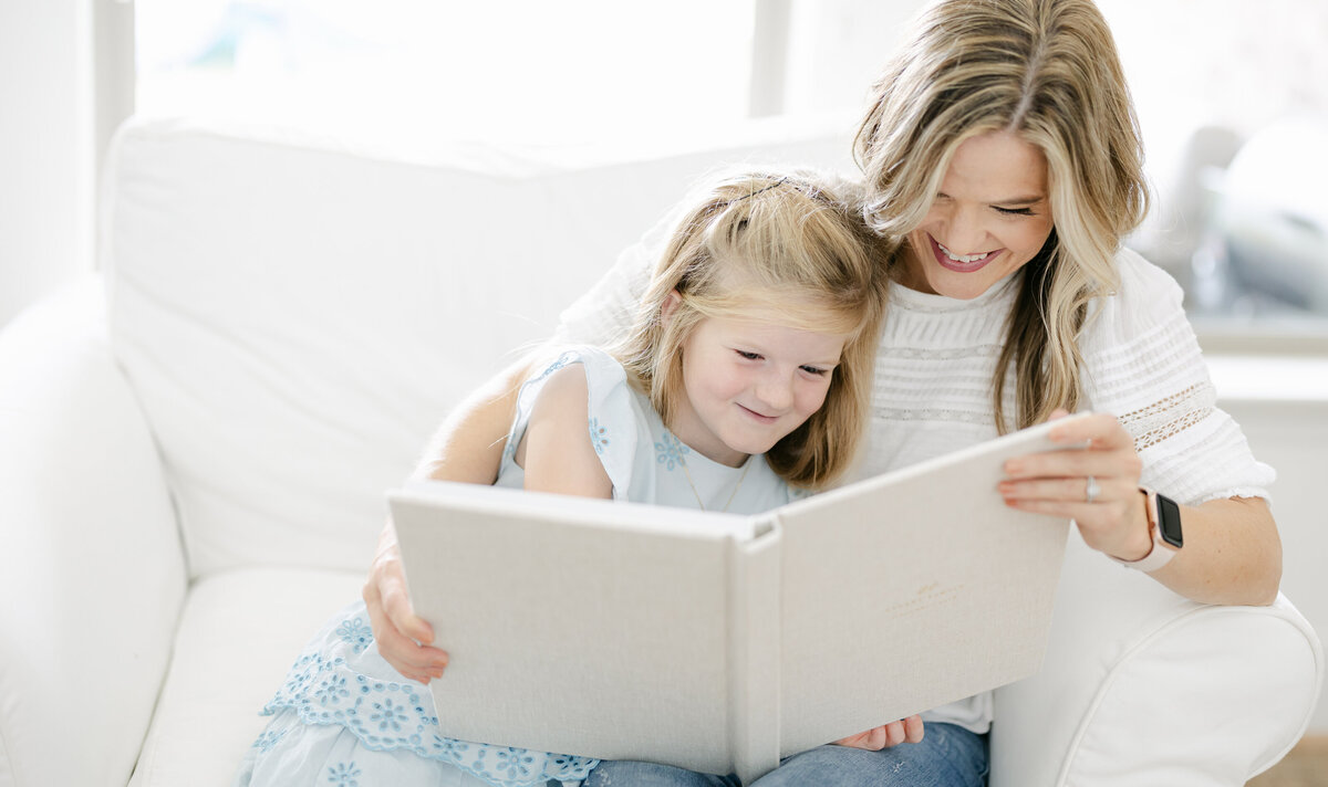 Kimberly and her daughter looking at a family heirloom album together