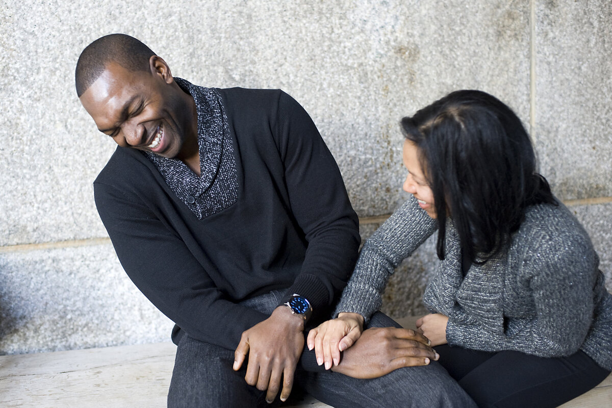 A couple sitting together and laughing 