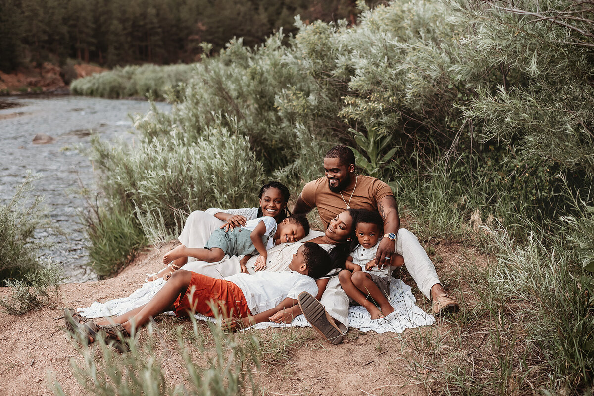 Family of six snuggling together at river near Denver