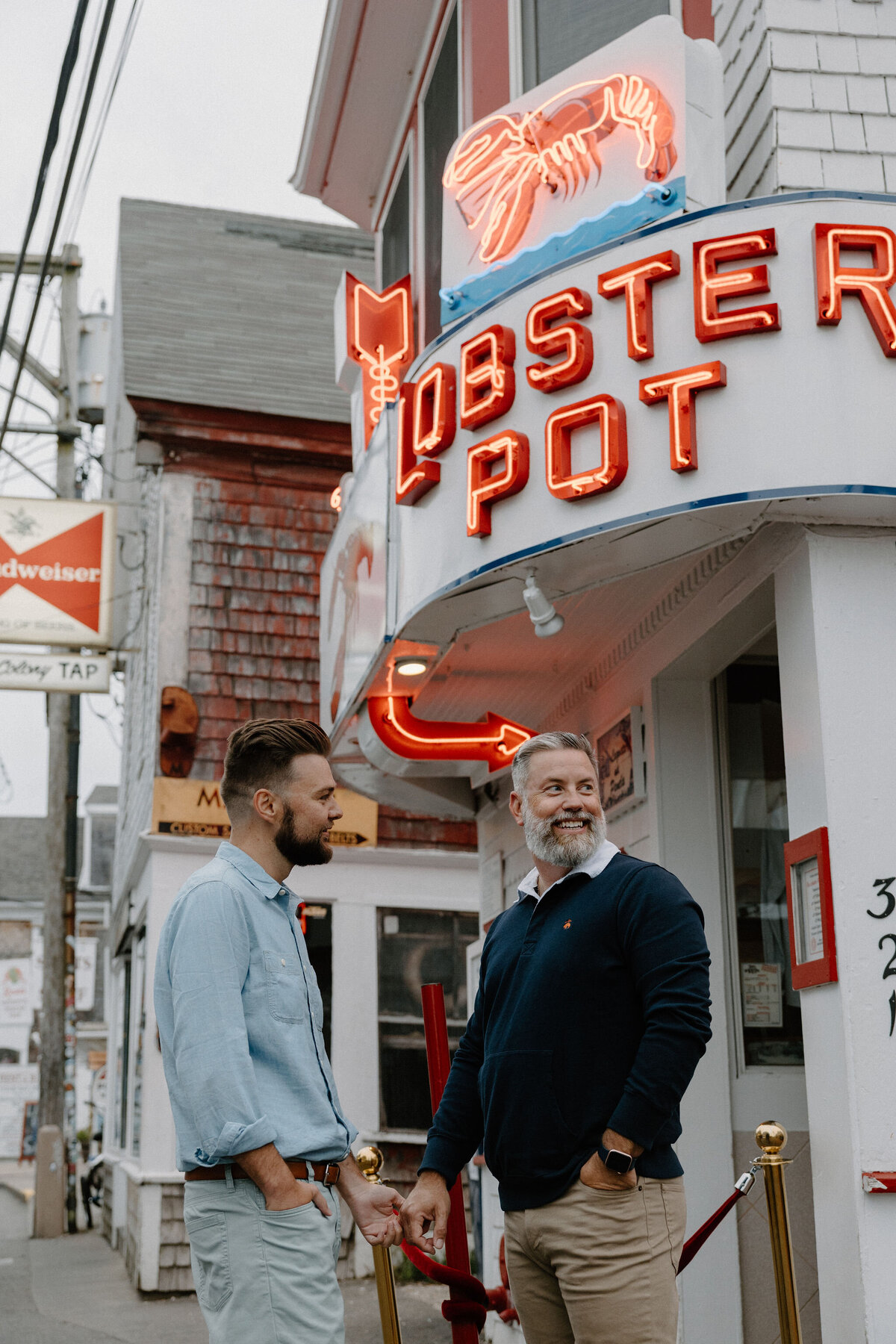engaged male couple in front of lobster restaurant