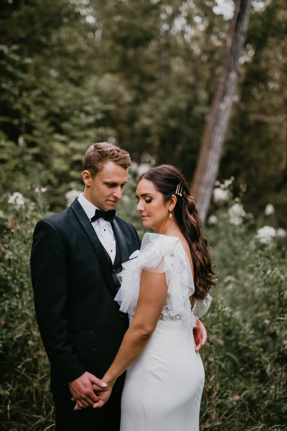 Elegant portrait of bride and groom in the trees captured by Nikki Collette Photography, adventurous and romantic wedding photographer in Red Deer, Alberta. Featured on the Bronte Bride Vendor Guide.