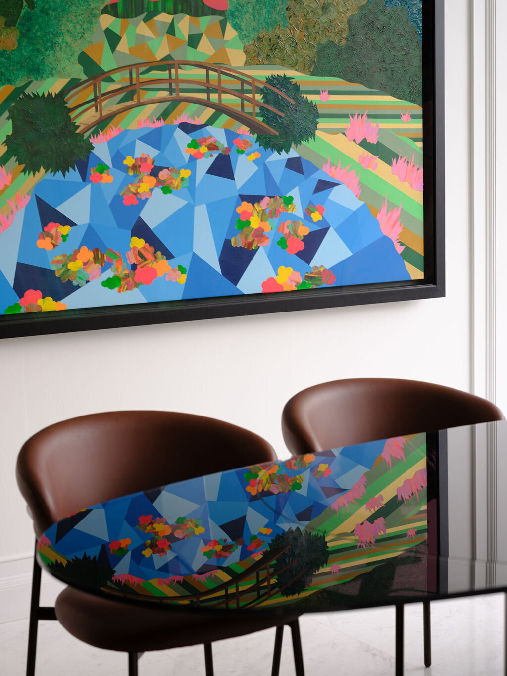 Dining table with brown chairs and artwork