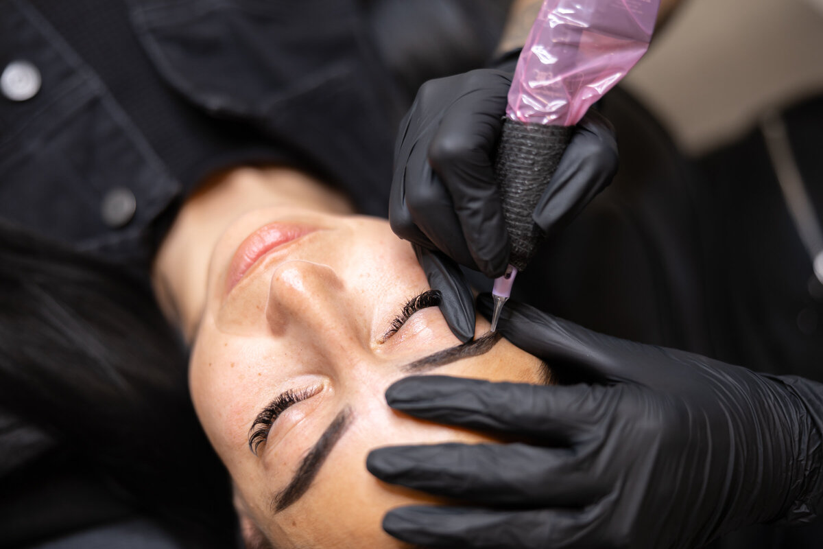 Close-up of woman smiling while receiving brow procedure in studio. Photograph by Yucaipa branding photographer Kaitlyn Dawn Photography.