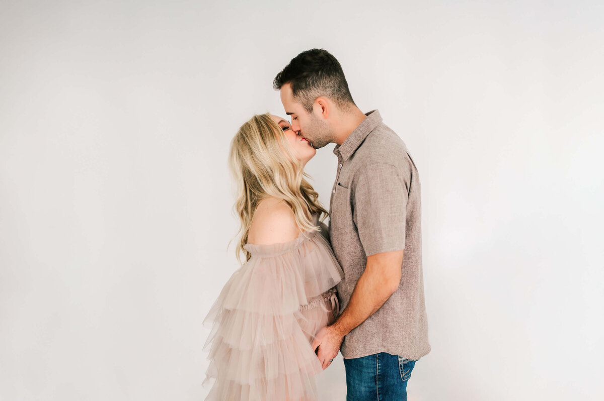 pregnant couple kissing in maternity photography studio in Springfield MO