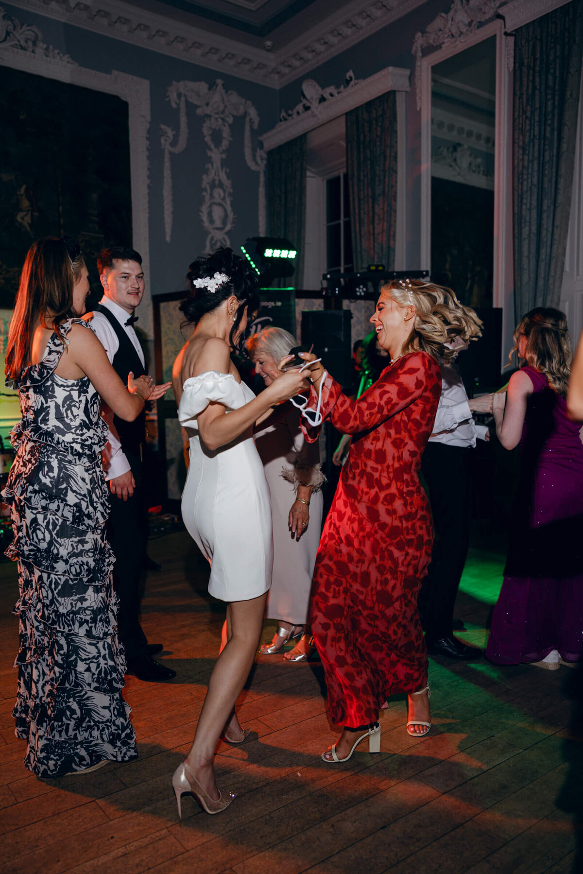 A candid wedding photo of the bride dancing with friends at her wedding at Luttrellstown Castle