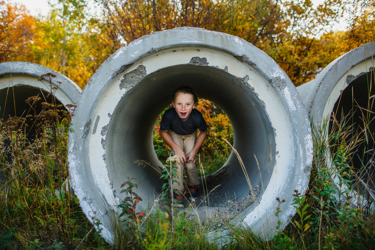 young boy runs through tunnel