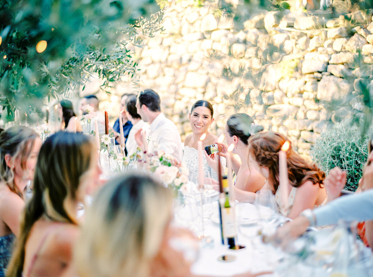 Film photograph of wedding reception with bride smiling and talking with guests photographed by Italy wedding photographer at Villa Montanare Tuscany wedding