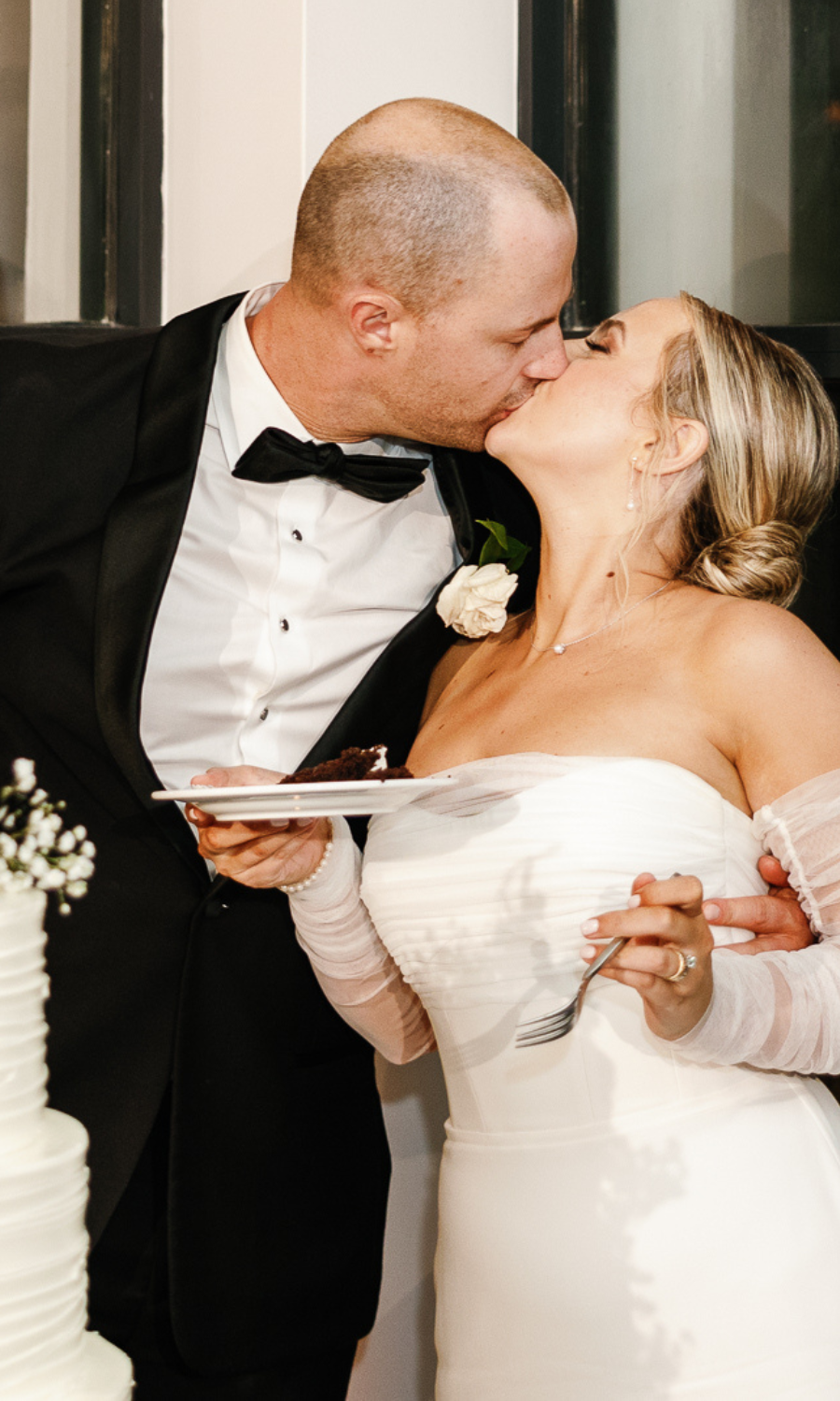 Bride and groom kissing during their cake cutting at Bakers Cay Resort, captured by Claudia Amalia. Claudia is a wedding and lifestyle photographer based in Miami and Florida Keys, South Florida. She specializes in destination weddings, offering elegant and memorable photography services.