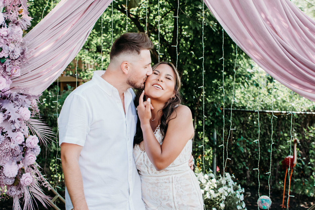 Groom kissing his bride at their backyard wedding in Streamwood, IL