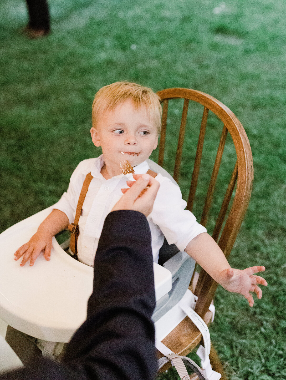 Child sitting on booster seat at Dallenbach Ranch Wedding reception Colorado
