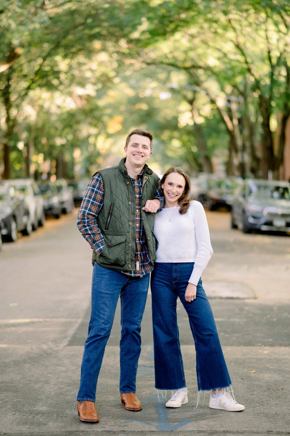 a couple standing in a city street with their arms linked