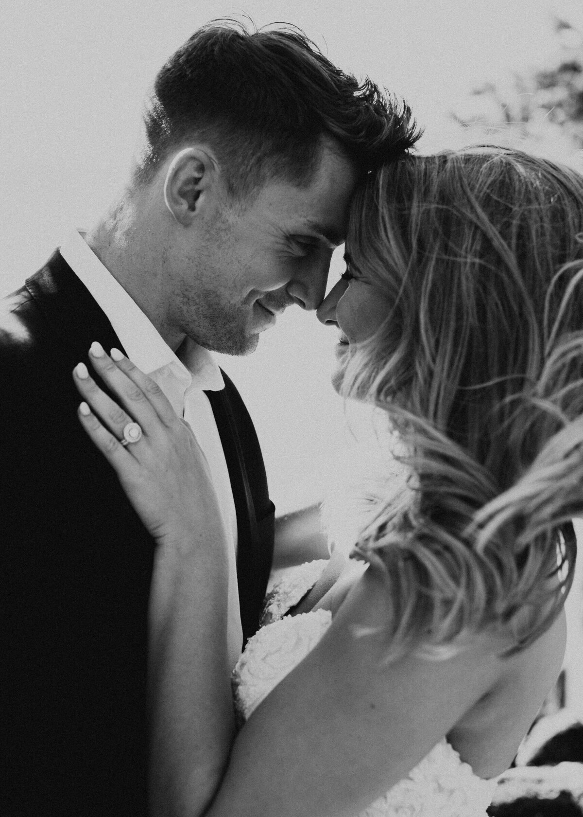 Couple touches noses and poses for a wedding photo in black and white