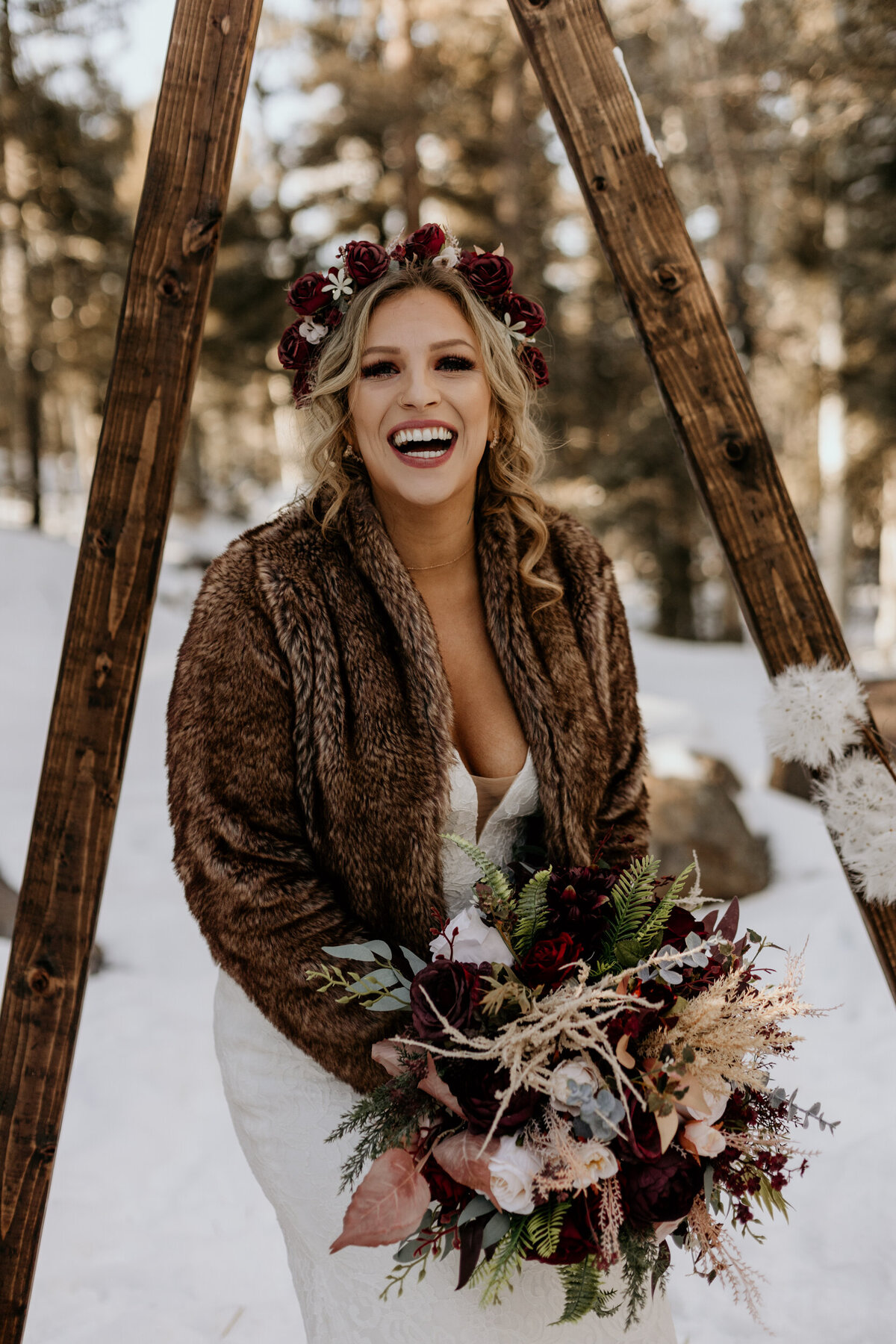 bride in a furry coat smiling in the snow