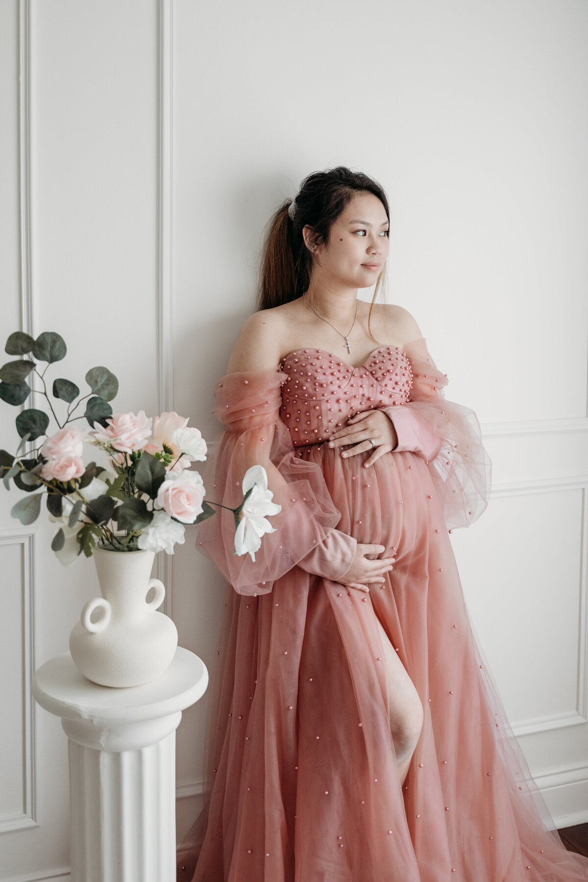 Pregnant mom wearing a pink gown thinking about her baby girl