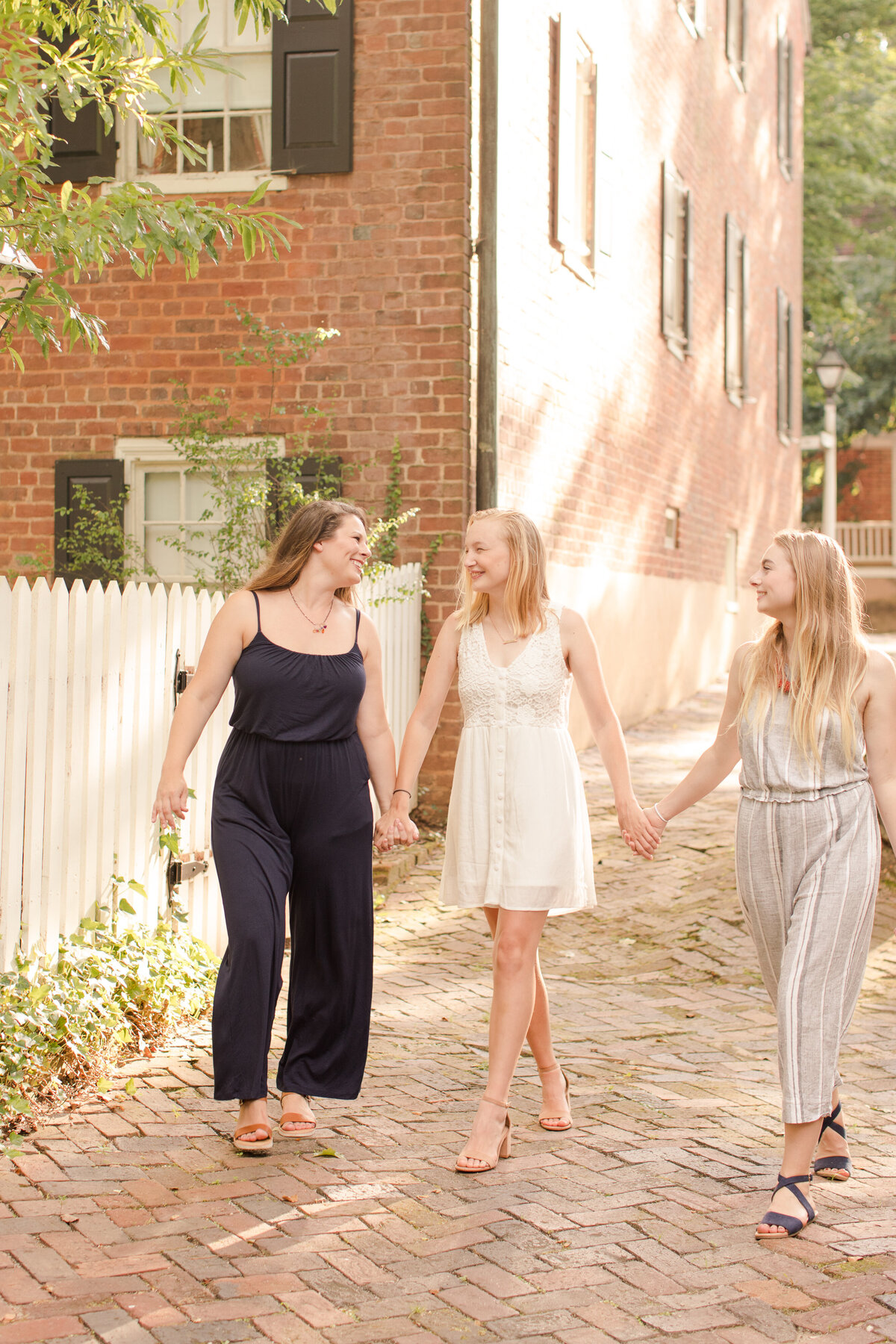 sisters walking down a sidewalk laughing