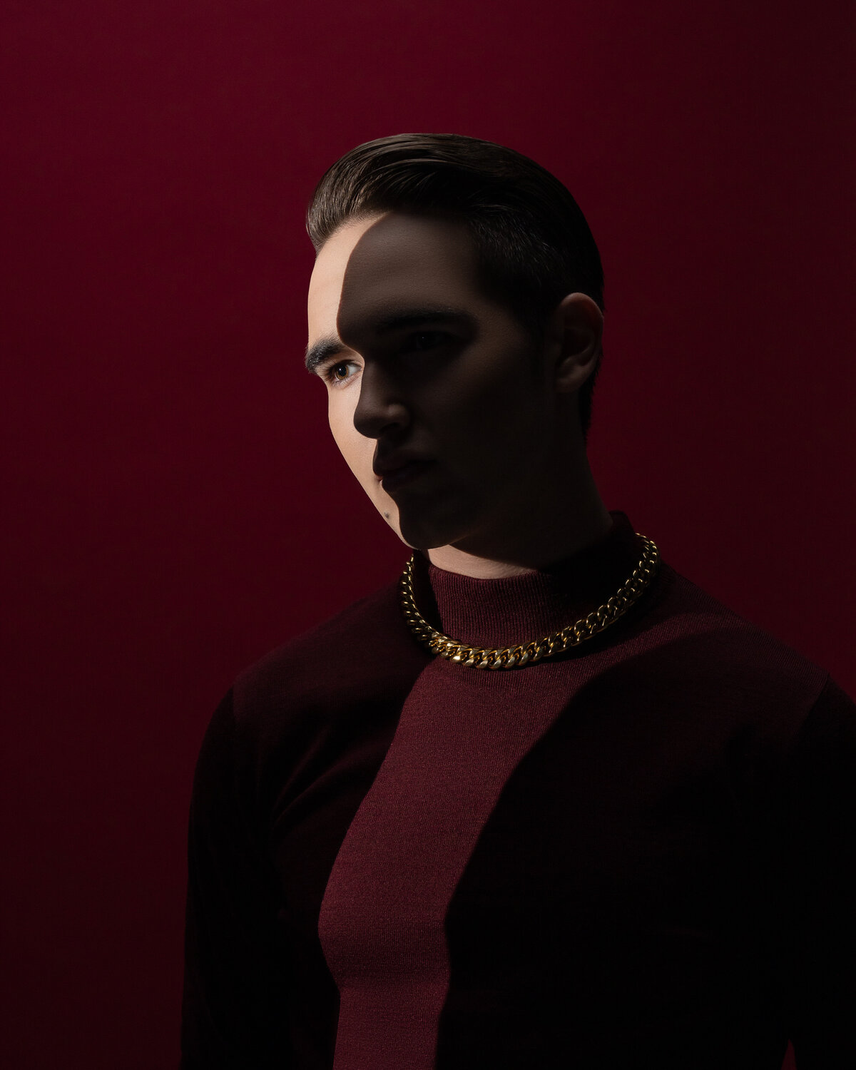 A young man in a maroon turtleneck