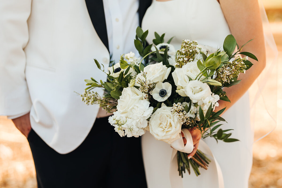 Bride and groom in black and white with bridal bouquet including anemones at River Run Lodge at Eagle Crest
