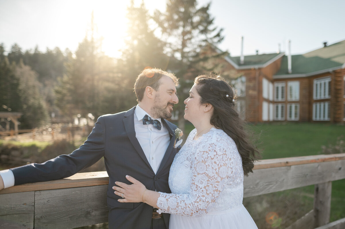 L’homme et la femme s’enlacent tendrement à l’Auberge du Vieux-Moulin à Sainte-Émélie-de-l’Énergie, dans Lanaudière, scène intime et chaleureuse d’un mariage célébré en pleine nature
